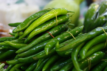 Bunch of green chili on the table at market.