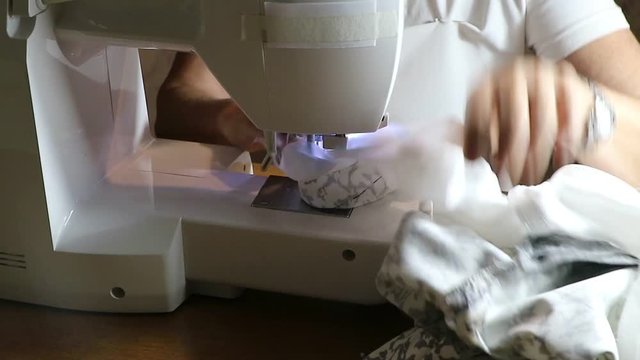Costurando roupas feitas artesanalmente em seu ateli&ecirc;