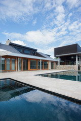 Modern mansion in front of swimming pool with blue sky