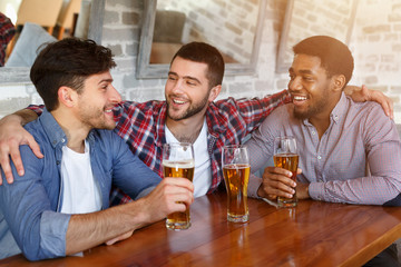 Best friends meeting and drinking beer in bar