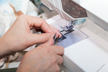 Seamstress hands at work, threads and needles