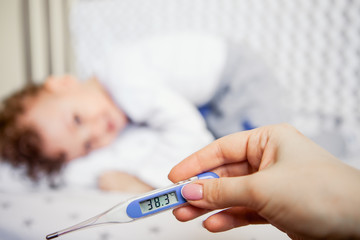 Naklejka premium flu epidemic. Close-up of a high-temperature thermometer. sick kid
