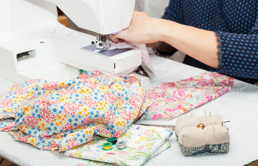 Seamstress hands at work, threads and needles