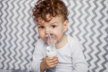 children's health. little boy with a nebulizer is sitting on a cot