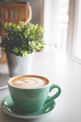 cup of coffee with flowers on wooden table