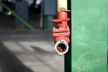 Fire red hydrant on a wall in an industrial warehouse manufactory factory. Fire protection