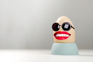 Funny egg with sunglasses and smile. Happy easter background
