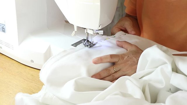 Costurando roupas feitas artesanalmente em seu ateli&ecirc;