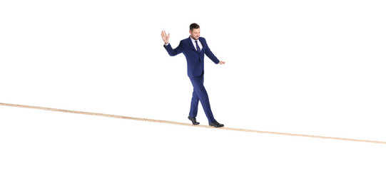 Full length portrait of businessman balancing on rope against white background