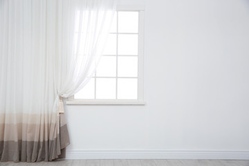 Modern window with curtain in room, space for text. Home interior