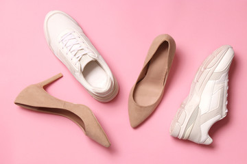  white sneakers and high heel shoes on a colored background top view. Women's shoes. Classic and sport shoes.