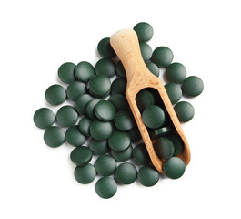 Scoop and spirulina tablets on white background, top view