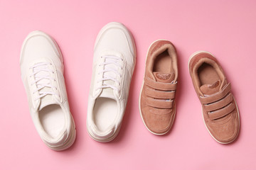  shoes for children and women's sneakers on a colored background top view. Footwear for children and adults.