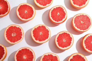 Fresh sliced ripe grapefruits on white background, top view