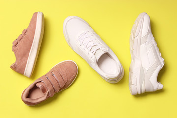  shoes for children and women's sneakers on a colored background top view. Footwear for children...