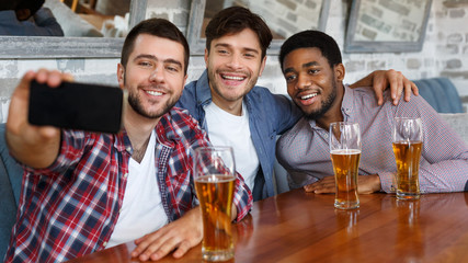 Friends making selfie and smiling, resting at pub