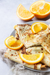 Crepes with orange, honey and natural yogurt or sour cream. Thin pancakes. Light concrete background. Copy space.