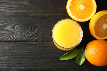 Glass with orange juice and fresh fruit on wooden background, flat lay with space for text