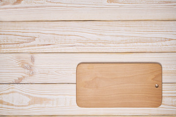 Old empty wooden  cutting board on white wooden background, top view