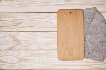 Old empty wooden  cutting board on white wooden background, top view