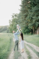 Fototapeta premium portrait of father and child. A stylish father with a beard keeps on his arms a child, a little girl, they embrace and smile, rejoice and have fun. Happy Father's Day