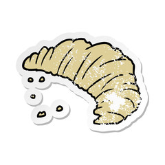 distressed sticker of a cartoon croissant
