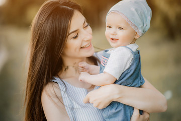 a young mother holds her daughter in the nature