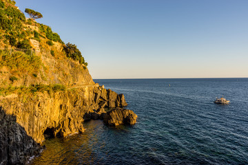 Golden sunset at the cliff at the Italian Riviera in the Village of Riomaggiore, Cinque Terre, Italy