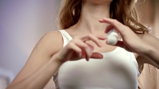 Young woman using deodorant roll on armpit. Woman body with deodorant underarm