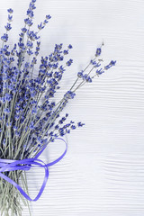 Natural lavender flowers on white old wood with copy space. Rustic flowery background. Selective focus.