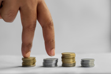 Savings, Finances, Investments, Economy and Home Budget. Fingers climb on piles of coins, symbolizing financial growth and progress in business.