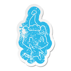 cartoon distressed sticker of a happy cat wearing santa hat