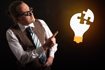 Funny nerd or geek looking to light bulb having an idea