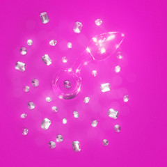 Glass butt plug and artificial diamonds are on a colored background.
