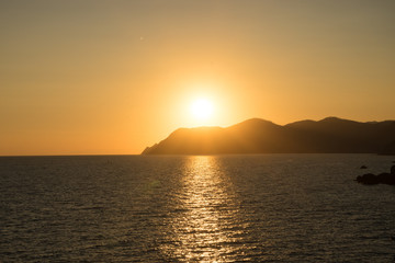 Fototapeta premium Golden sunset at the cliff at the Italian Riviera in the Village of Riomaggiore, Cinque Terre, Italy
