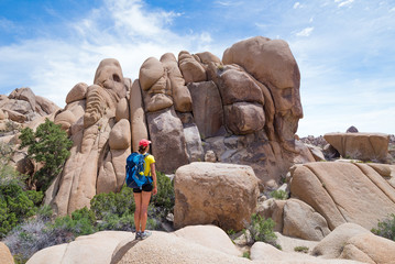 Young woman looking at the Skull Rock in Joshua Tree National Park, California, USA. Adventure and travel concept.