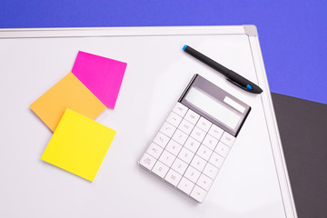 Modern workplace with notebook, pen and calculator isolated on blue black background