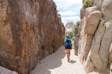 Young woman walking in Joshua Tree National Park, California, USA. Adventure and travel concept.