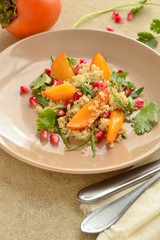 Quinoa salad with persimmon, pomegranate and fresh herbs, vertical