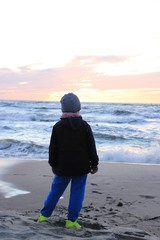 Child against the sea. Sunset.
