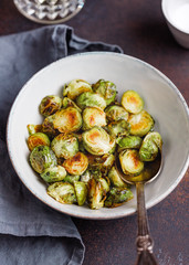 Ceramic bowl with roasted brussel sprouts on a table. The concept of healthy vegetarian eating.