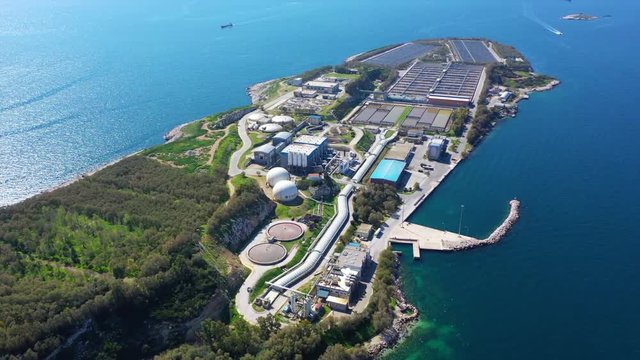 Aerial drone bird's eye video from island of Psitaleia the largest sewage treatment plant in Europe, Saronic gulf, Peiraeus, Attica, Greece