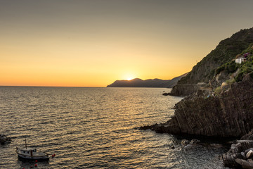 Golden sunset at the cliff at the Italian Riviera in the Village of Riomaggiore, Cinque Terre, Italy
