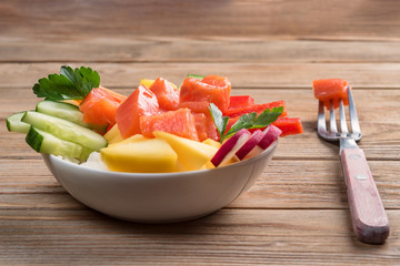Poke salad from hawaii with fork on wooden background. Close up. Soft focus. To prepare it just...