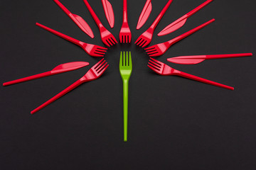 Disposable red and green plastic forks isolated on background