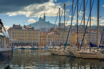 The Old Port Vieux Port of Marseille with Basilique Notre-Dame de la Garde blurred in the fog and...