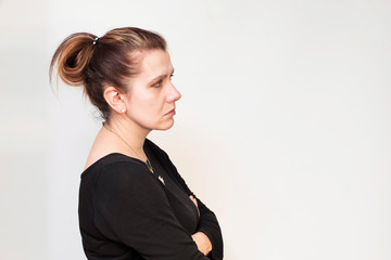 Portrait of a sad middle-aged woman in a profile on a light background. The woman looks forward and...