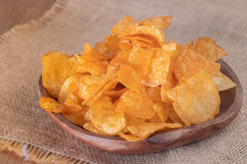 close up of Crispy potato chips on wooden bowl