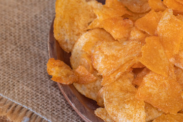 close up of Crispy potato chips on wooden bowl