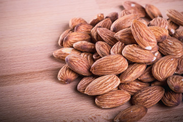 Close up pile of almonds on wooden floor,background.
